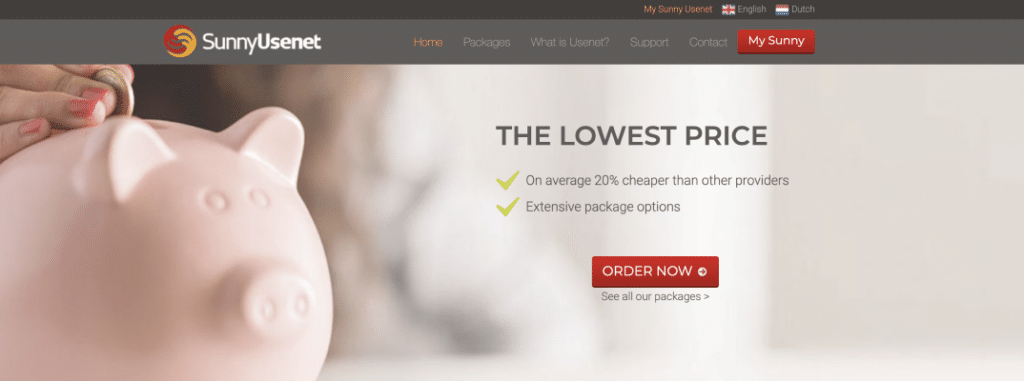 A woman's hand is putting a coin into a piggybank