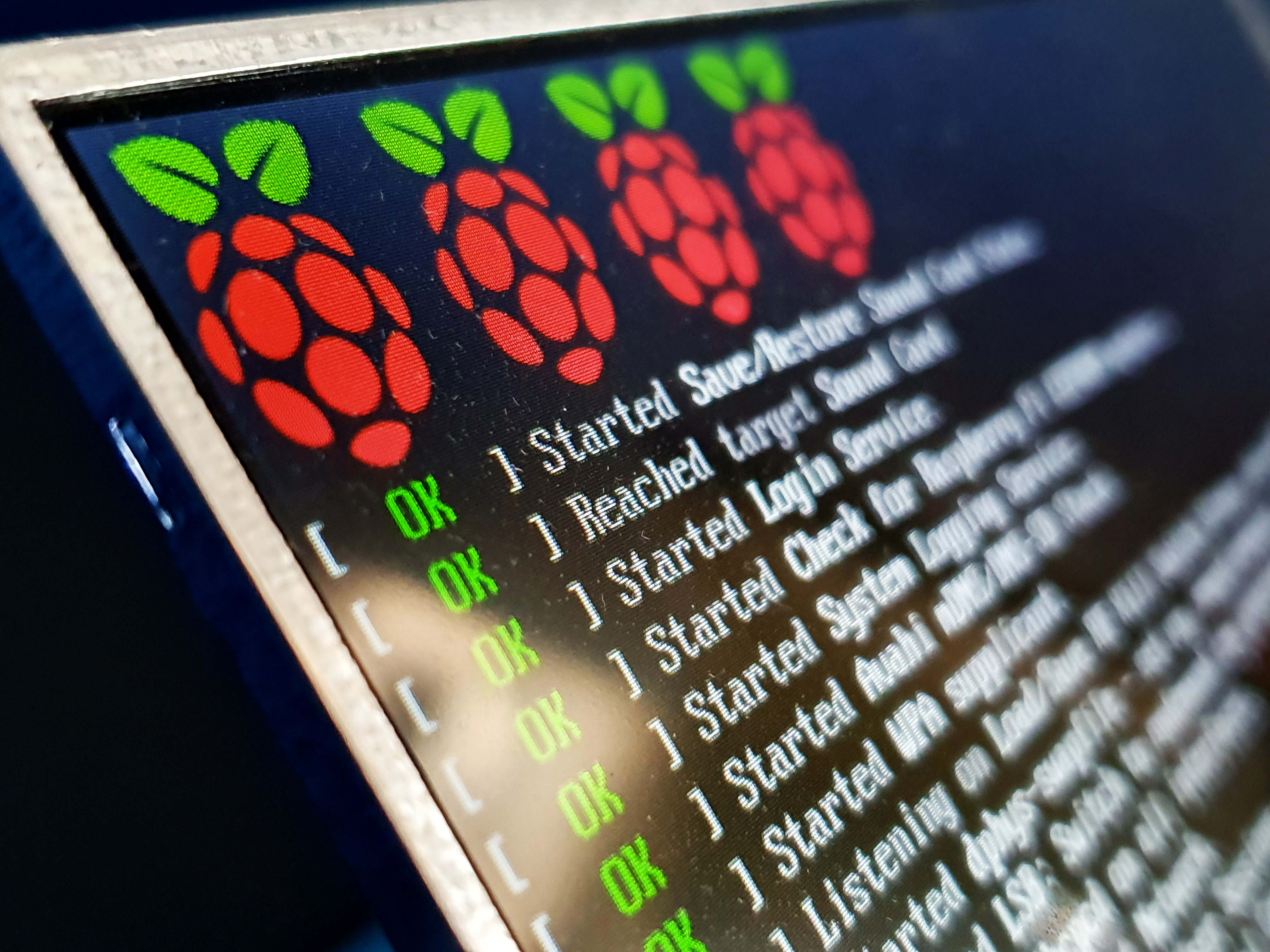 Closeup of a computer screen showing the startup of a Raspberry Pi loading Raspbian