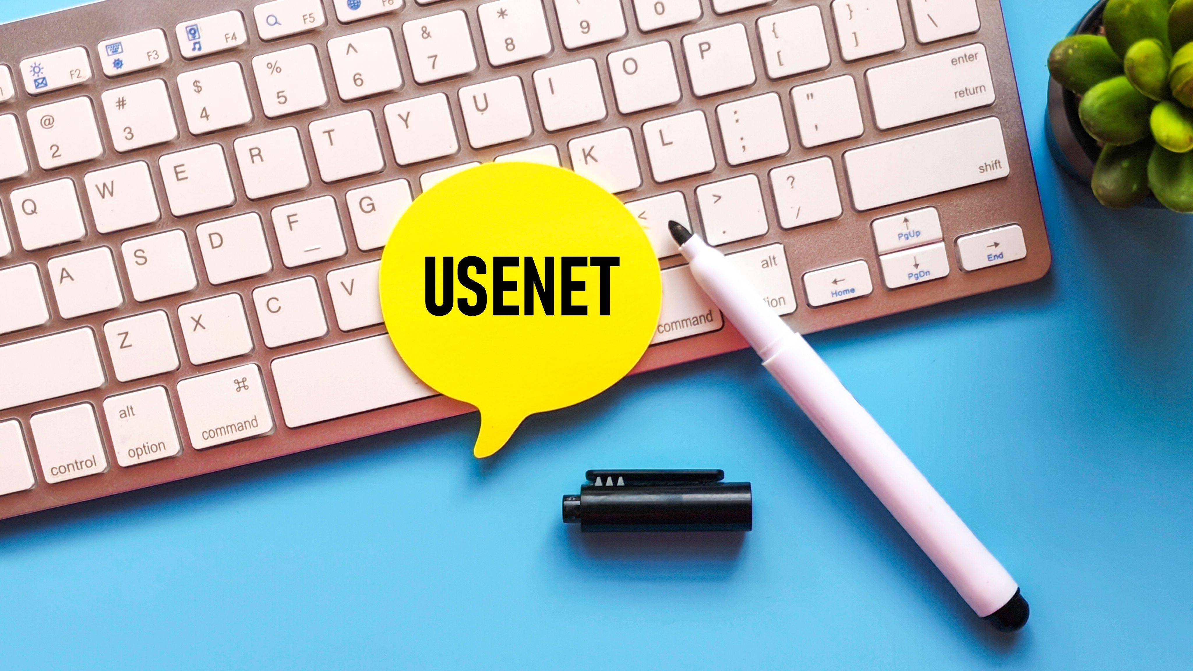 Yellow speech bubble that says, "Usenet" on a white keyboard.